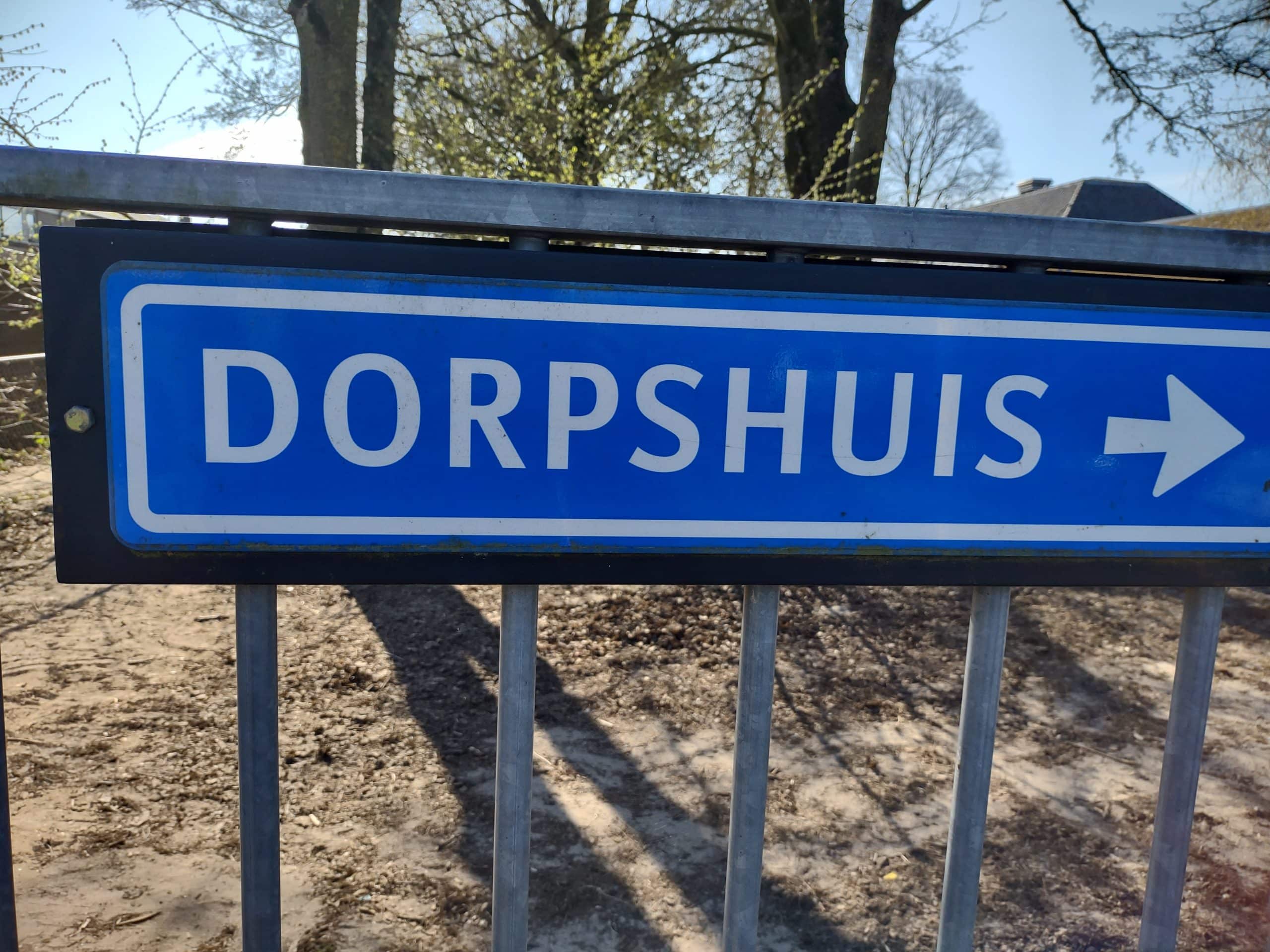 Afbeelding van een straatnaambord met daarop 'dorpshuis'